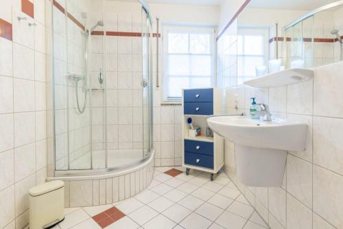 a white bathroom with a sink and a shower at Fewo Seelenanker in Thiessow
