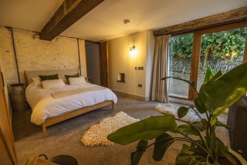 a bedroom with a bed and a large window at The Dairy in Lifton