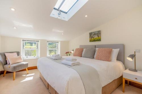 a bedroom with a large white bed and a chair at 3 Bed in Gunnerside oc-ds097 in Gunnerside