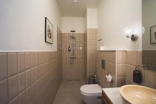 a bathroom with a shower and a toilet and a sink at Mia Hotel in Orissaare