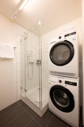 a washing machine and a shower in a bathroom at Stadtloft Suites Zürich- Oerlikon in Zurich