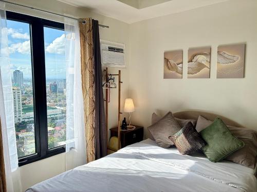 a bedroom with a bed and a large window at Peaceful Studio at The Median - City Skyline View, Short Walk to IT Park in Cebu City