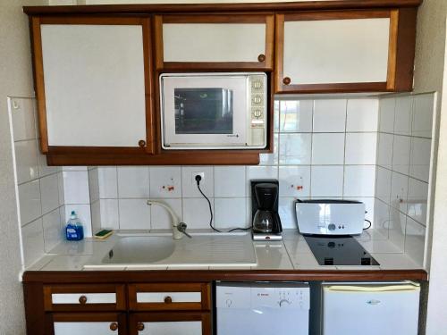 uma cozinha com um lavatório e um micro-ondas em Résidence Turquoise Guadeloupe - Vue mer et lagon em Le Gosier