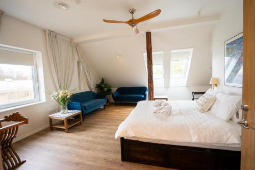 a bedroom with a bed and two blue chairs at Mia Hotel in Orissaare
