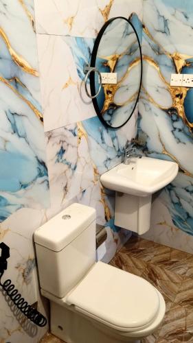 a bathroom with a sink and a toilet and a mirror at Hotel Green Garden PVT LTD in Trincomalee