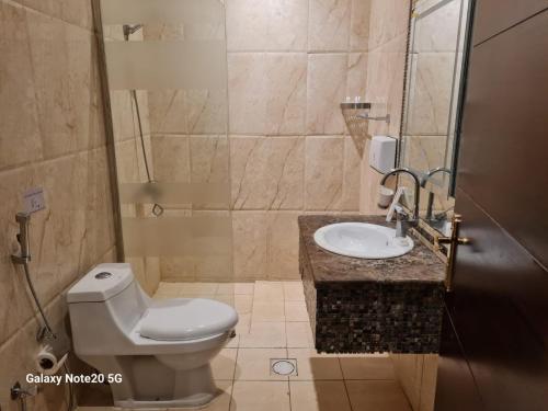 a bathroom with a toilet and a sink at Taleen Serviced Apartments Al-Ahsa- تالين الاحساء للشقق المخدومة in Ruqaiqah