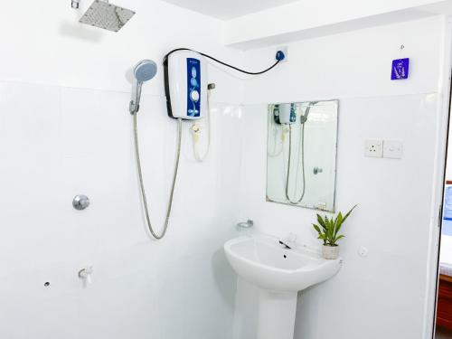 a bathroom with a sink and a phone on the wall at The Bay House in Weligama