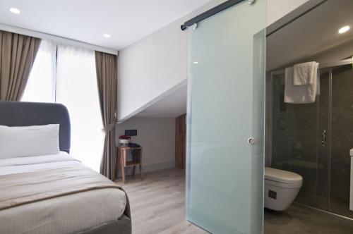 a bedroom with a bed and a glass shower door at Forty Nişantaşı Hotel & SPA in Istanbul