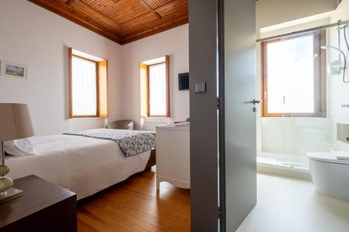 a bedroom with a bed and a tub and a sink at Casa Afonso - Passadiços do Paço in Aveiro