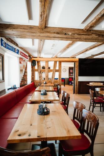 a restaurant with wooden tables and a red couch at Braustube Wehle in Dunningen