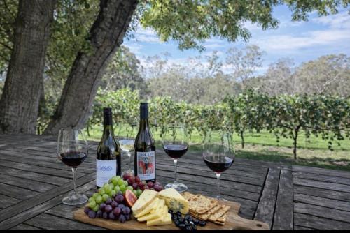 a table with two bottles of wine and wine glasses at Woodlands - Vineyard setting in Penwortham