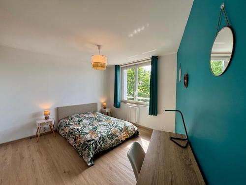 a bedroom with a bed and a table and a window at La Boierie - City Appart's in La Flèche