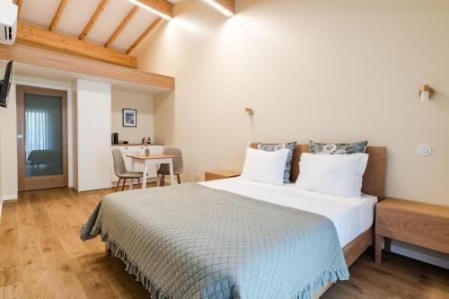 a bedroom with a large bed and a table at Casa Da Avó Custódia in Campo do Gerês