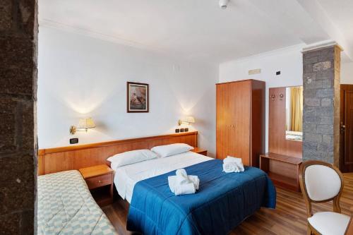 a hotel room with a bed with towels on it at B&B H Pompeii Ruins in Pompei
