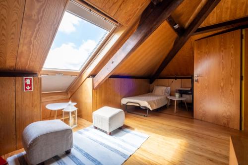 an attic room with a window and a table and chairs at Casa Afonso - Passadiços do Paço in Aveiro
