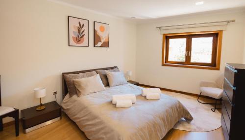 a bedroom with a bed with two towels on it at Refugio do Couto in Cabeceiras de Basto