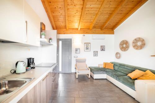 a kitchen and living room with a green couch at Camping Italia 90 Apartments in Domaso