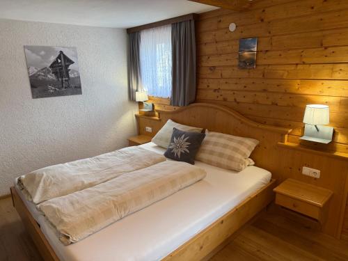 a bedroom with a bed in a wooden wall at Gästehaus Zugspitzblick in Berwang