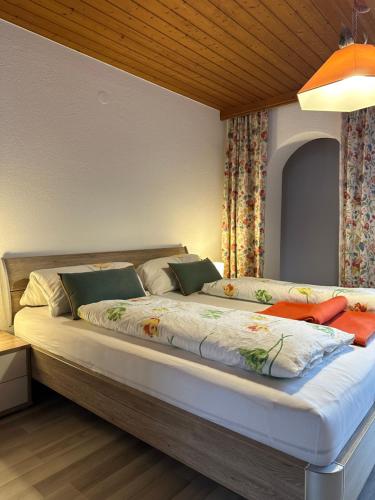a bedroom with a large bed with pillows at Haus Raimund in Längenfeld