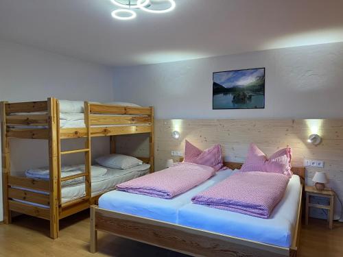 a bedroom with two bunk beds and a ladder at Berghaus Biberwier in Biberwier
