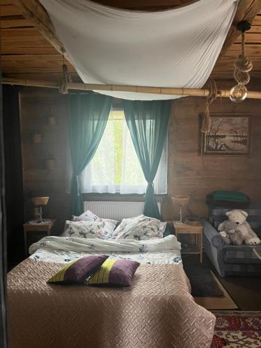 a bedroom with a bed with a canopy and a window at Ślimakowa chatka jak u babci in Parczew