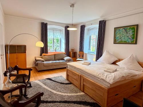 a bedroom with a large bed and a couch at FeWo Altes Doktorhaus in Berchtesgaden