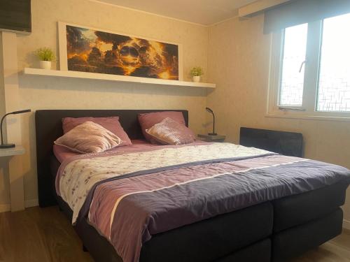a bedroom with a large bed with pillows on it at Enigma Lounge Chalet with swimming pool in Zutendaal
