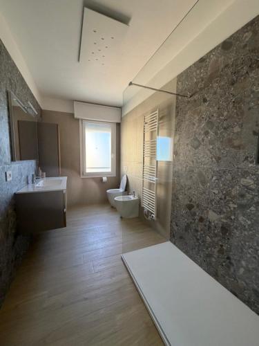 a bathroom with a sink and a toilet and a window at Velù Apartment in Porto Viro