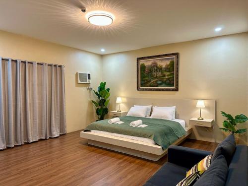 a bedroom with a bed and a couch at The Penthouse at Sapphire in San Agustin