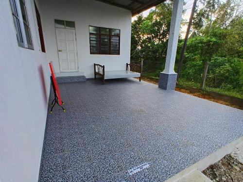 a front porch of a white house with a bench at Homestay Puteri D'Durian Guling in Bukit Payong