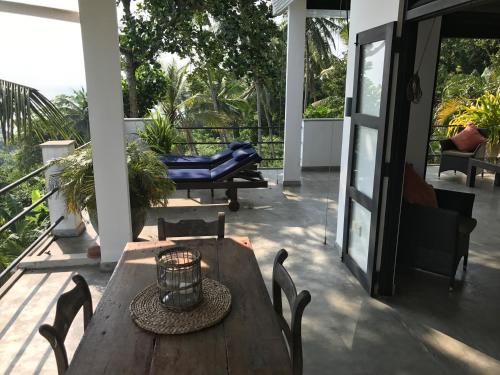 a wooden table and chairs on a patio at Lara's place in Unawatuna