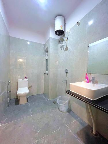 a bathroom with a sink and a toilet and a mirror at Bunk Hostel Tapovan in Rishīkesh