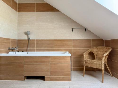 a bathroom with a bath tub and a chair at Villa Sobótka in Sobótka