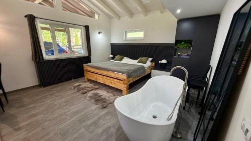 a bathroom with a tub and a bed and a bath tub at Casa Ducaru Moieciu de Sus in Moieciu de Sus