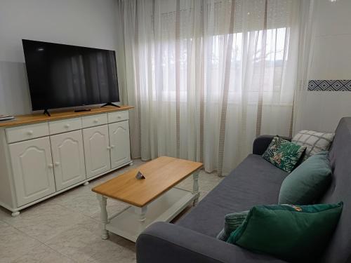 a living room with a couch and a flat screen tv at Hotel Rodeiramar in Cangas de Morrazo