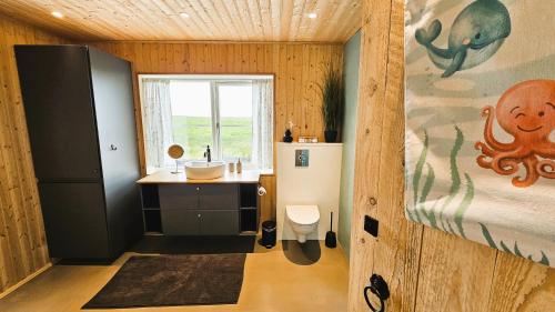 a bathroom with a sink and an octopus painting on the wall at The Forgotten Farmhouse in Skogar