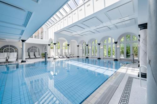 a large swimming pool in a building with windows at Relais & Châteaux Chasa Montana in Samnaun