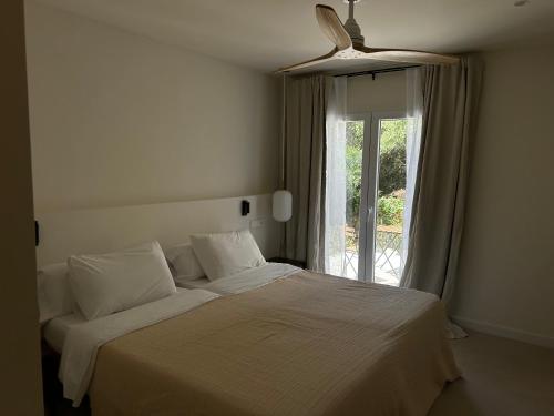 a bedroom with a white bed with a window at Serena Sol Apartments - Adults Only - Over 12 in Cala Serena