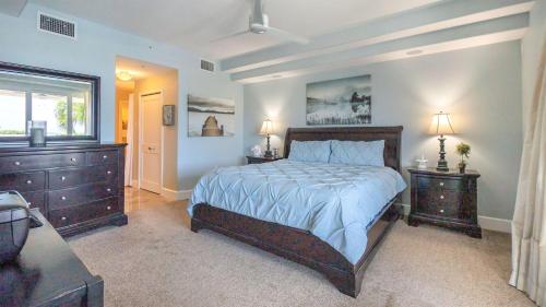 a bedroom with a bed and two dressers and a window at 123 Mariners Club in Key Largo