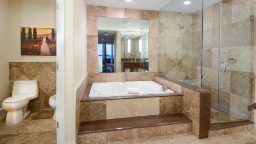 a bathroom with a tub and a toilet and a shower at 124 Mariners Club in Key Largo