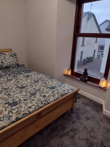 a bedroom with a bed and a window at DRIFTWOOD coastal holiday flat - newly refurbished with 2 bedrooms in Largs