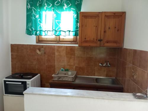 a kitchen with a sink and a stove at Alex Apartments in Roda