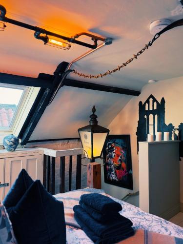 a bedroom with a bed and a lamp in a room at Rose Cottage in Whitby