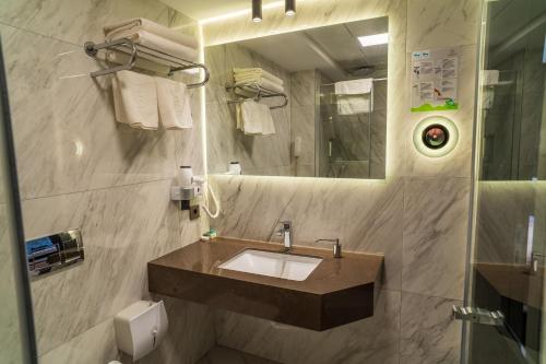 a bathroom with a sink and a mirror and towels at Selçuk Hotel in Konya