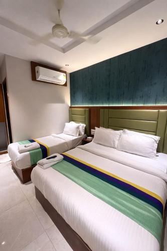 a bedroom with two beds with rainbow stripes on them at Ruby Hotel in Mumbai