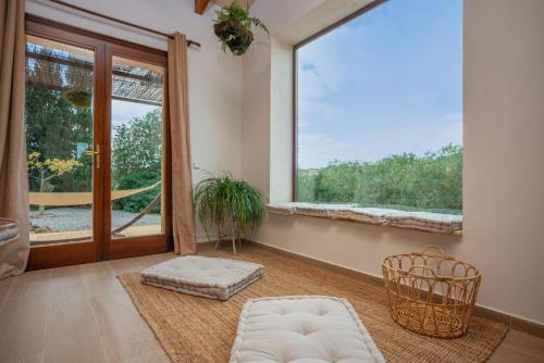 a living room with a large window and a chair at Sa Punta in Son Carrió