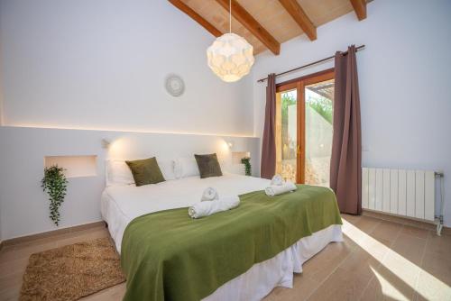 a bedroom with a large bed with towels on it at Sa Punta in Son Carrió