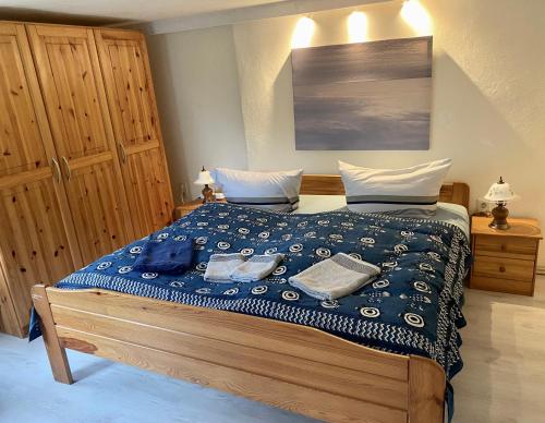 a bedroom with a bed with a blue comforter at Haus Wünsche in Wieck