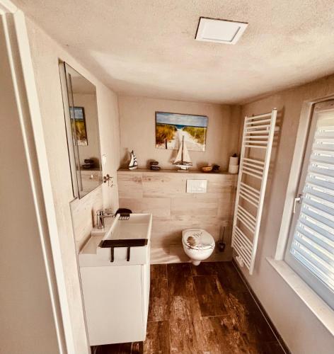 a white bathroom with a sink and a toilet at Haus Wünsche in Wieck