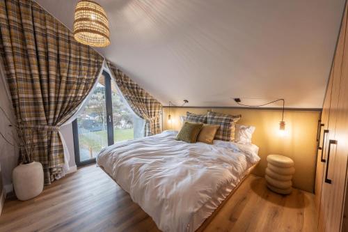 a bedroom with a bed and a large window at Sadova Chalet in Sadova